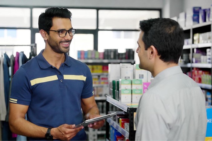 Vendedor de ruta profesional visitando un cliente en tienda de ferretería/papelería/ropa